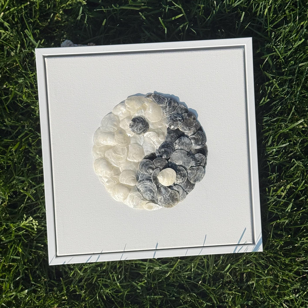 Framed artwork of a yin yang symbol on grass